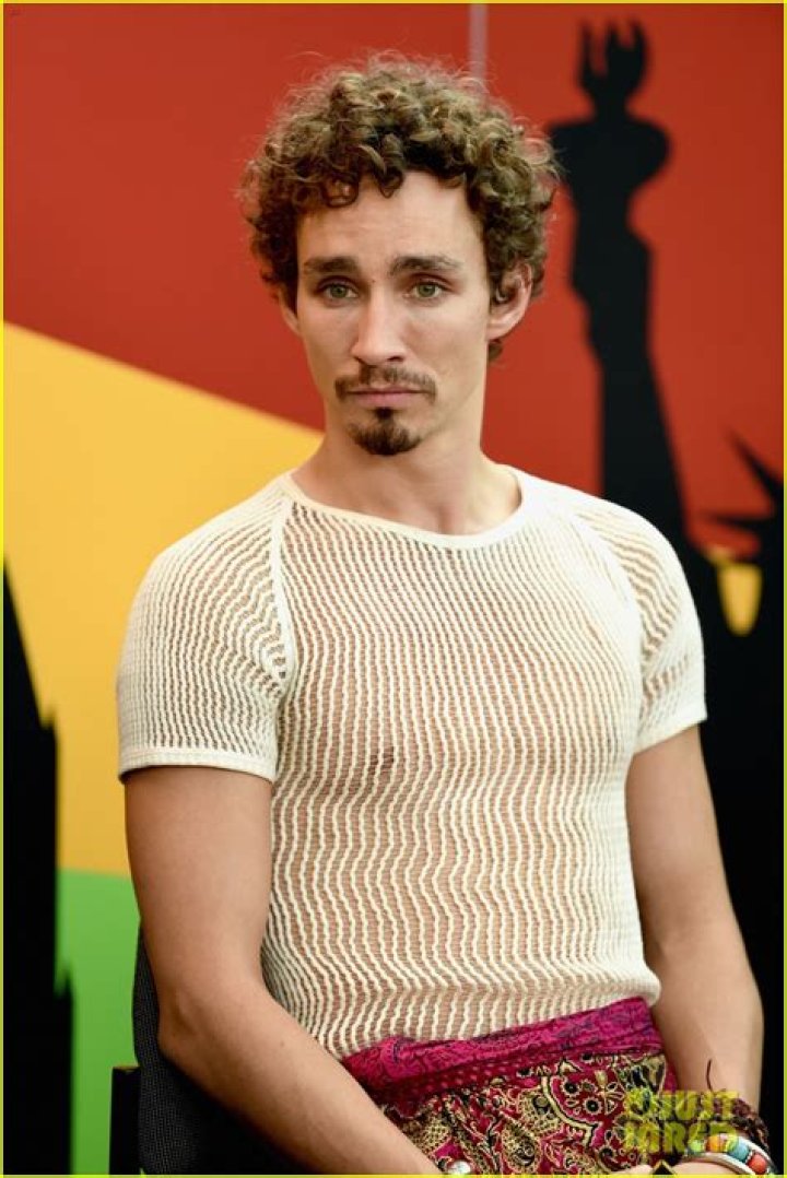 Mortal Engines’ Robert Sheehan Wears Sheer Shirt & Sarong to Comic Con
