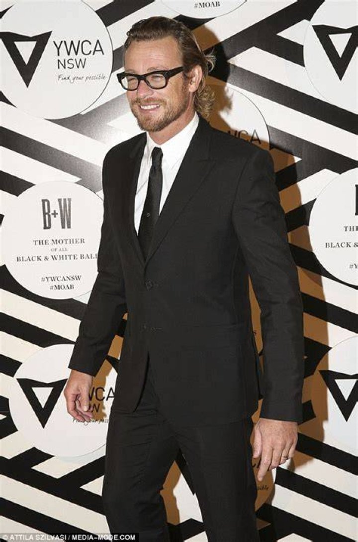 Simon Baker plants big smacker on wife's cheek at Mother Of All Balls