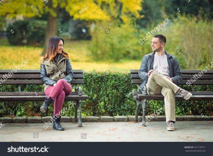 two young people sitting on a couch with one holding his arm around the